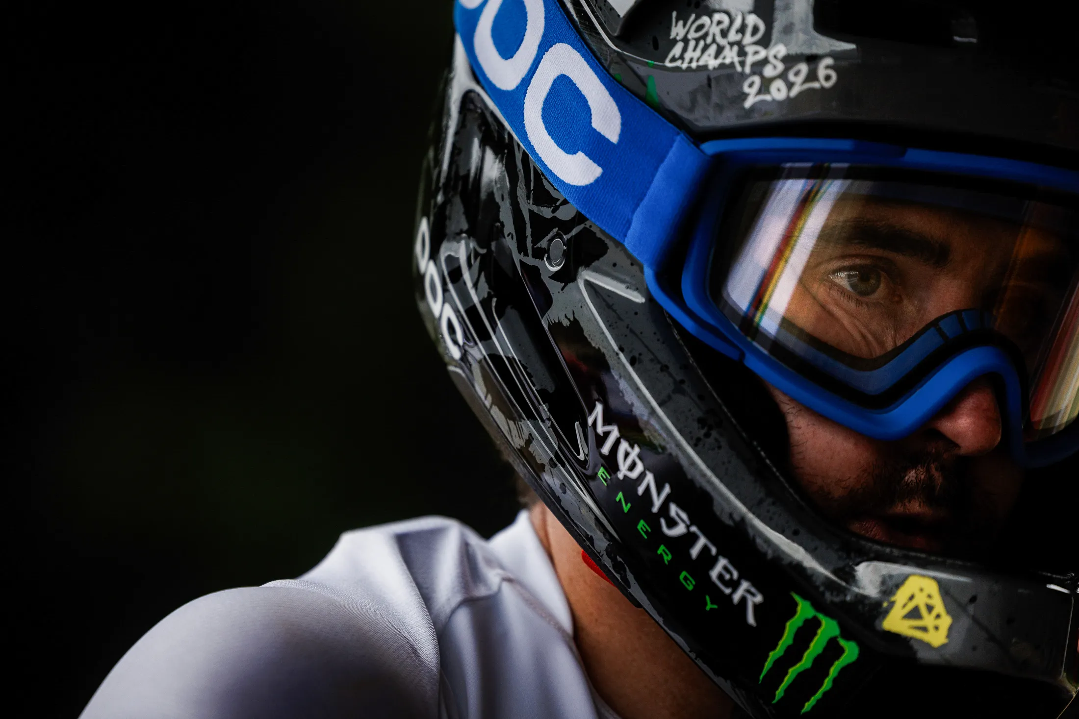 A rider in a full-face helmet and goggles, shot close in black and white